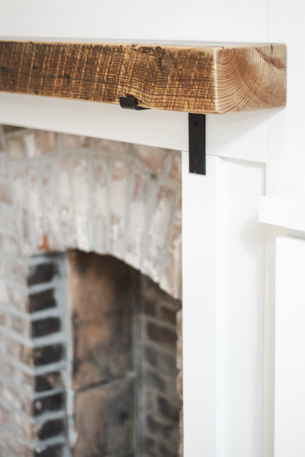 Reclaimed wood mantel over brick